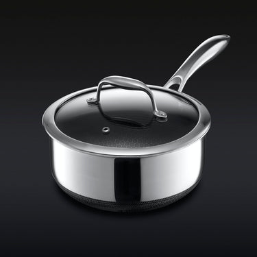 Hybrid stainless steel saucepan with glass lid and long handle on dark background